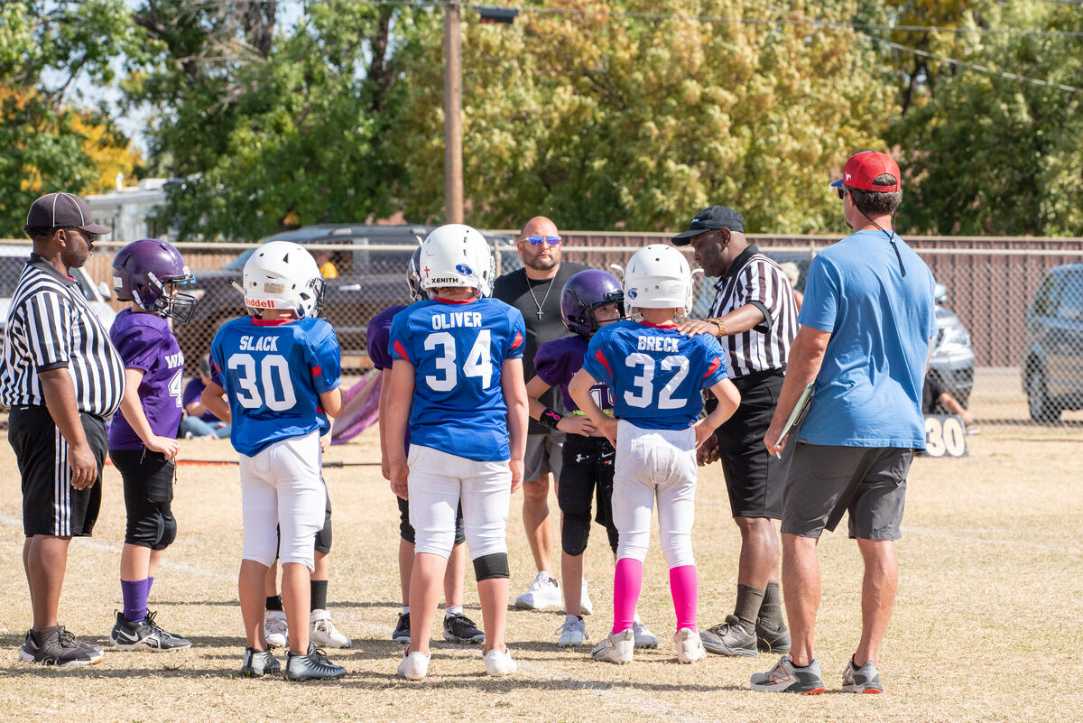 Players and coaches in a huddle on the field